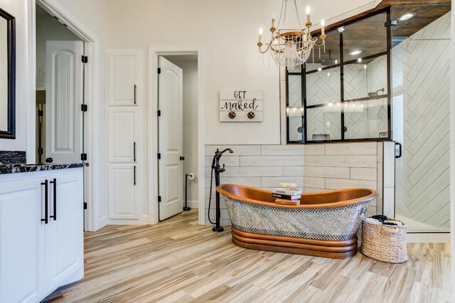 bathroom with tile walls, vanity, wood-type flooring, and shower with separate bathtub