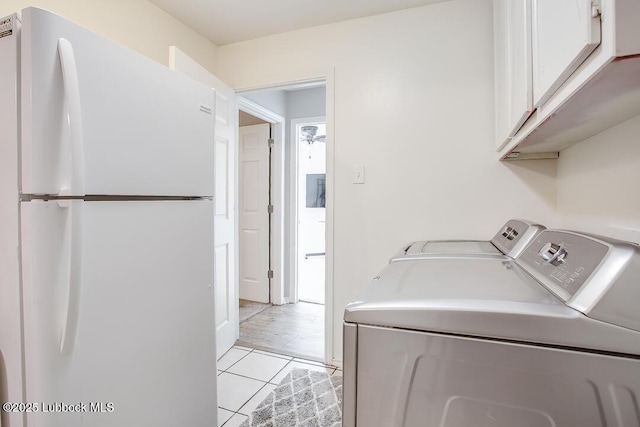2912 76th St, Lubbock, TX 79423 - washroom with separate washer and dryer, cabinet space, and light tile patterned floors
