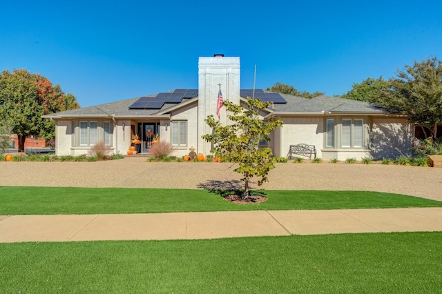 view of front of property featuring solar panels