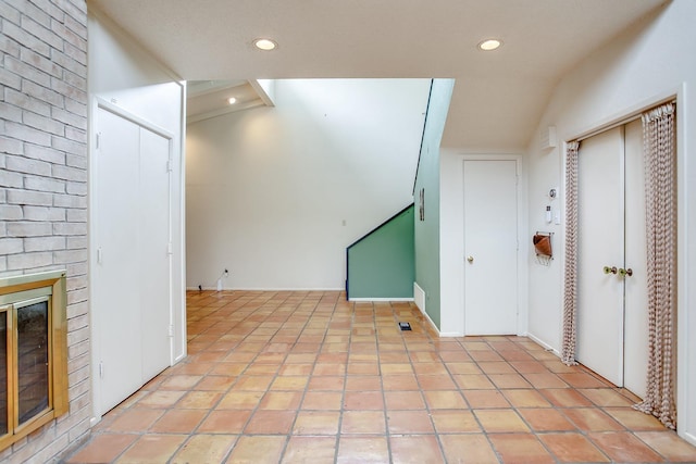 interior space featuring light tile patterned flooring and a brick fireplace