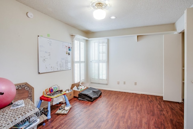 miscellaneous room with dark hardwood / wood-style floors and a textured ceiling