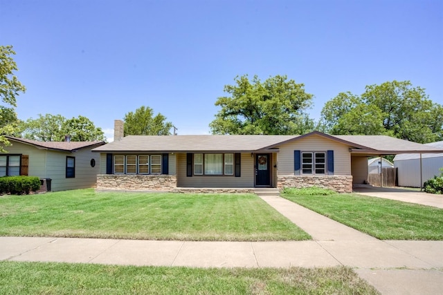 ranch-style home featuring a carport and a front lawn