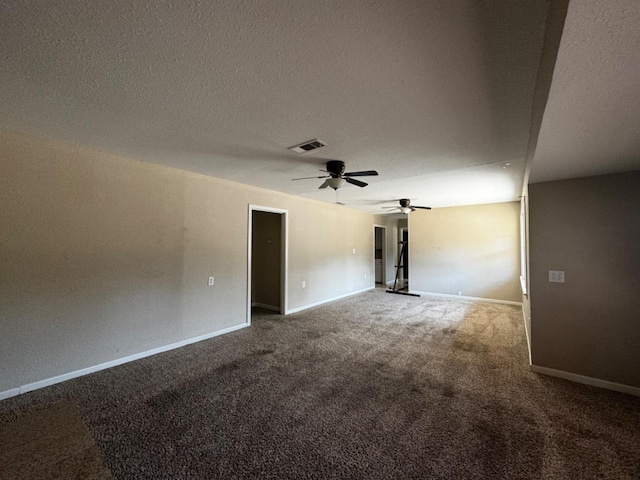 carpeted spare room featuring ceiling fan and a textured ceiling