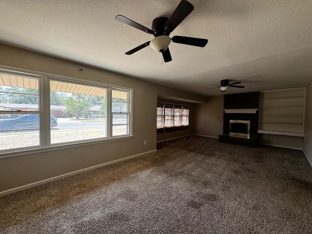 unfurnished living room with dark colored carpet, ceiling fan, and a textured ceiling