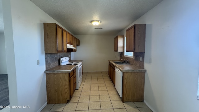 6210 22nd St, Lubbock, TX 79407 - kitchen with white appliances, under cabinet range hood, backsplash, a textured ceiling, and baseboards