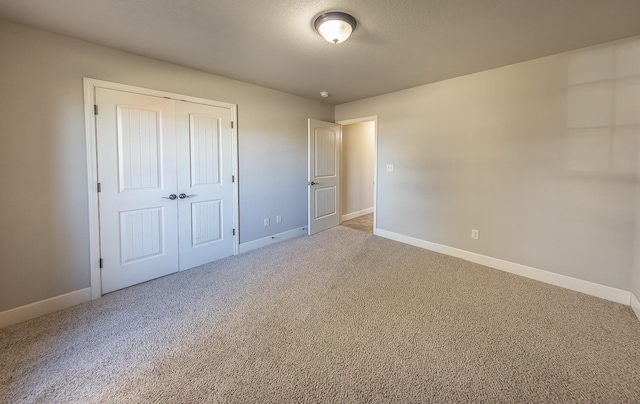 unfurnished bedroom featuring carpet, a textured ceiling, and a closet