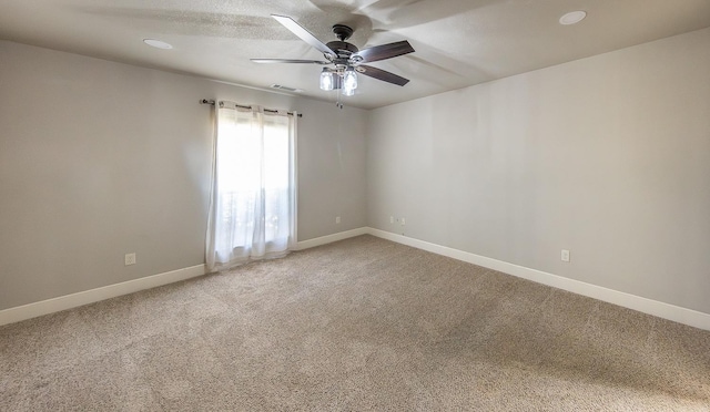 carpeted spare room featuring ceiling fan