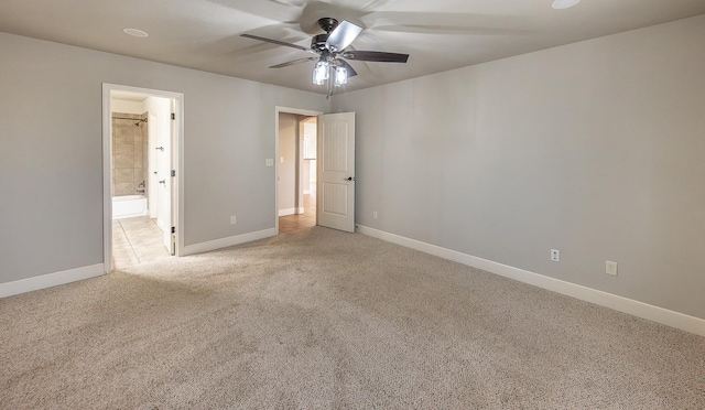 unfurnished bedroom featuring ceiling fan, ensuite bathroom, and light carpet