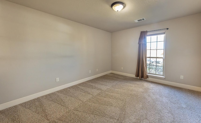 unfurnished room with carpet flooring and a textured ceiling