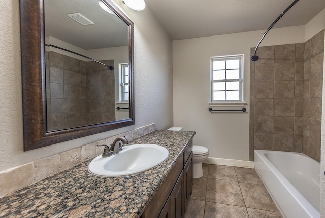 full bathroom featuring vanity, tiled shower / bath combo, tile patterned floors, and toilet