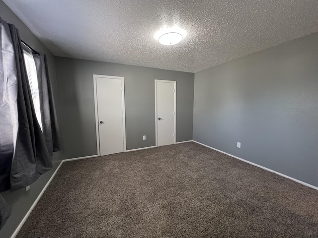 unfurnished bedroom featuring a textured ceiling and carpet