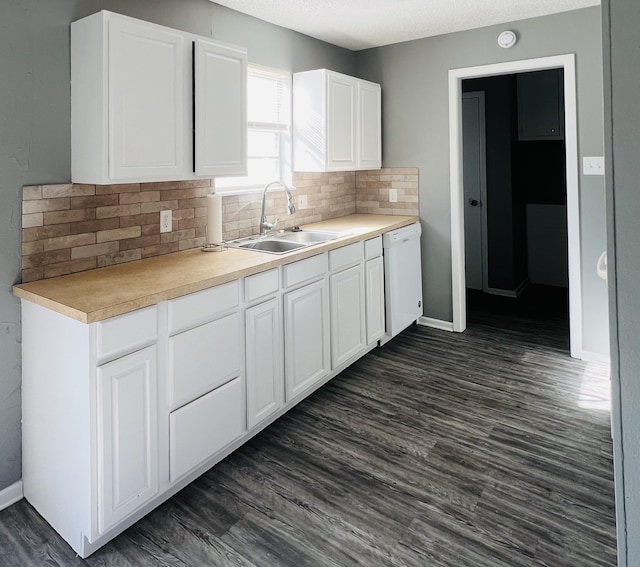 kitchen with sink, dark hardwood / wood-style floors, white cabinets, and dishwasher