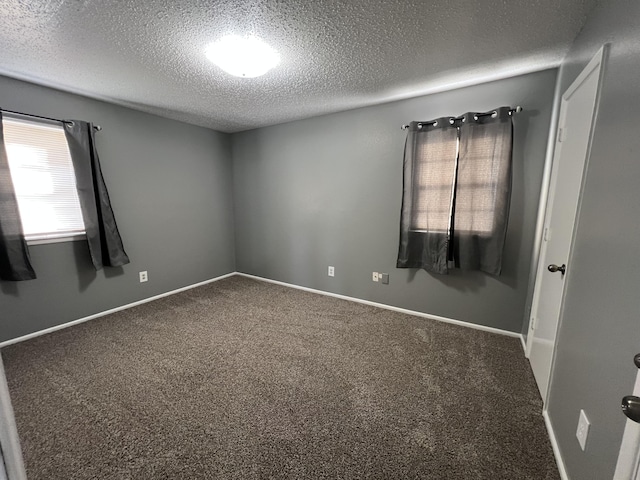 carpeted empty room featuring a textured ceiling