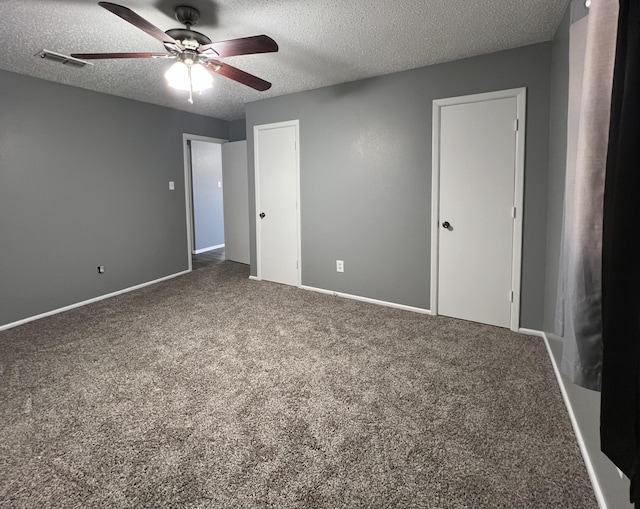 unfurnished bedroom featuring ceiling fan, a textured ceiling, and carpet flooring