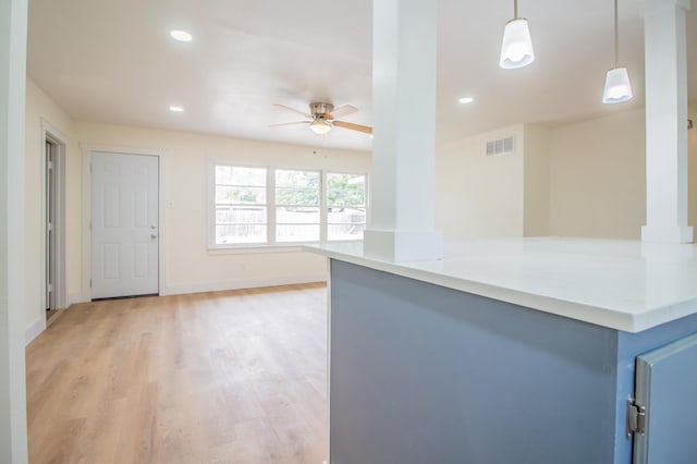 kitchen featuring hanging light fixtures, ceiling fan, and light wood-type flooring