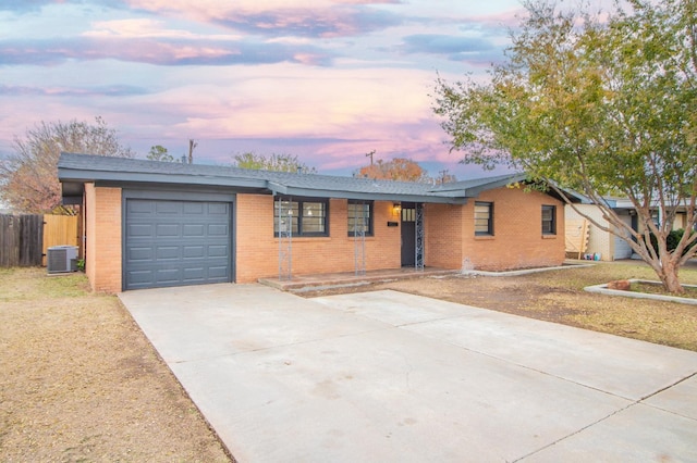 single story home featuring a garage and cooling unit