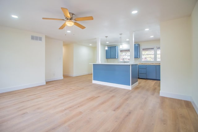 kitchen featuring blue cabinets, sink, a center island, ceiling fan, and light hardwood / wood-style floors