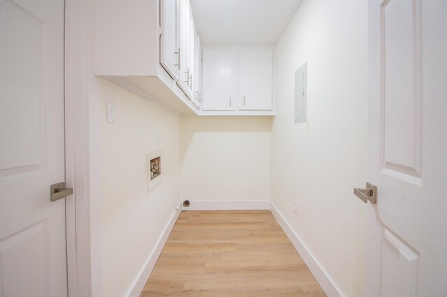 laundry area with cabinets, hookup for a washing machine, and light wood-type flooring