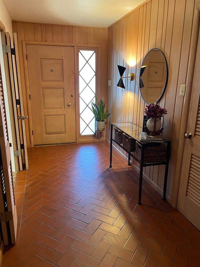 entryway featuring wood walls