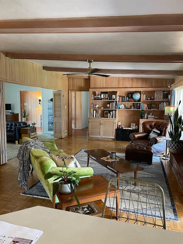 living room with parquet floors, beamed ceiling, and wood walls