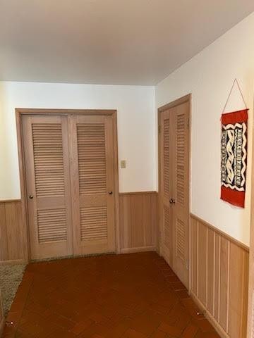 hallway featuring wood walls