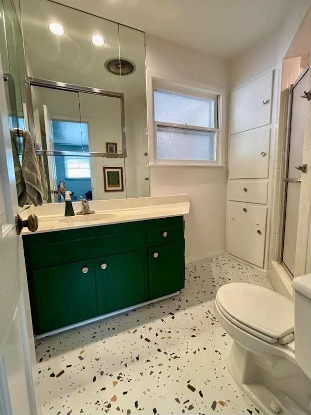 bathroom featuring walk in shower, vanity, toilet, and a wealth of natural light