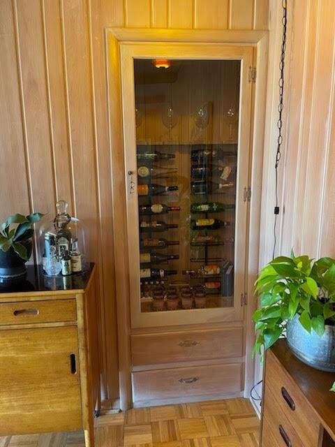 wine area featuring light parquet flooring and wooden walls