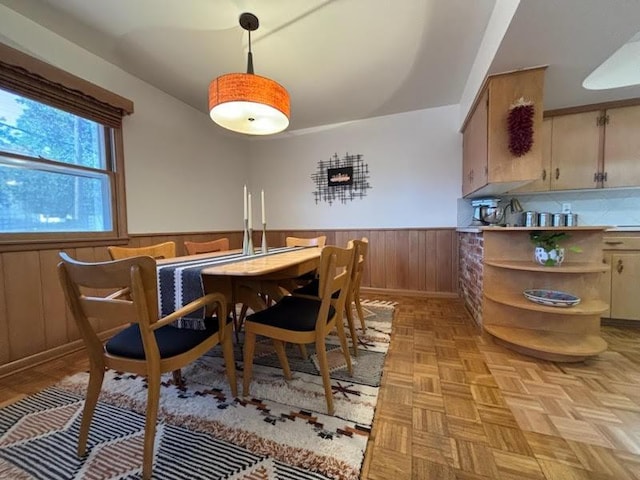 dining area with light parquet flooring and wooden walls