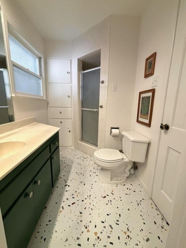 bathroom with vanity, toilet, and an enclosed shower