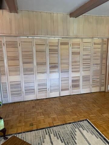 interior space with beamed ceiling and parquet floors