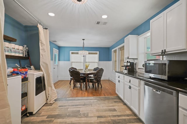 kitchen featuring pendant lighting, stainless steel appliances, light hardwood / wood-style floors, and white cabinets