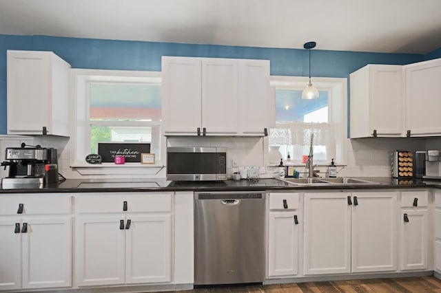 kitchen with white cabinetry, appliances with stainless steel finishes, a healthy amount of sunlight, and pendant lighting