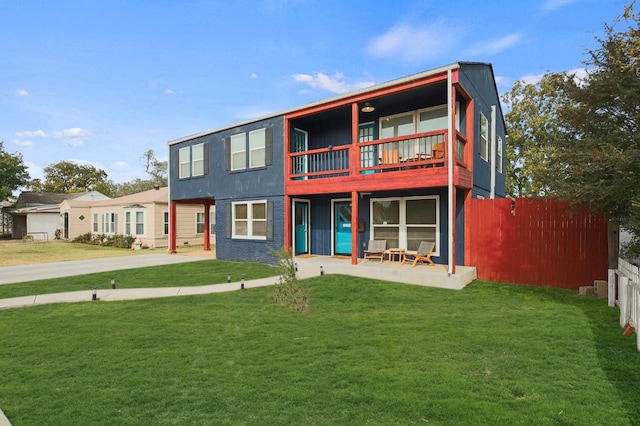 view of front of home featuring a balcony, a front yard, and a patio area