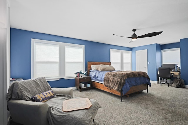 bedroom featuring ceiling fan, carpet floors, and multiple windows