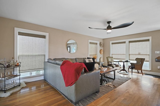 living room with dark wood-type flooring and ceiling fan