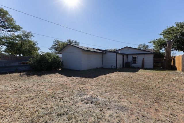 back of house featuring a storage unit and a lawn