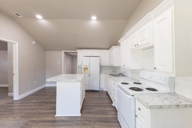 kitchen with lofted ceiling, sink, a kitchen island, white appliances, and white cabinets