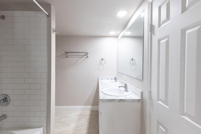 bathroom with tiled shower / bath and vanity