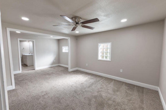 carpeted spare room featuring ceiling fan and a textured ceiling