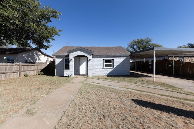 view of front of property featuring a front lawn and a carport