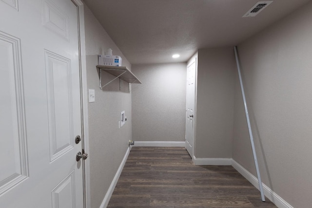 laundry area with dark wood-type flooring and a textured ceiling