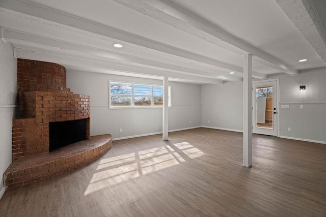 basement with a brick fireplace and hardwood / wood-style floors