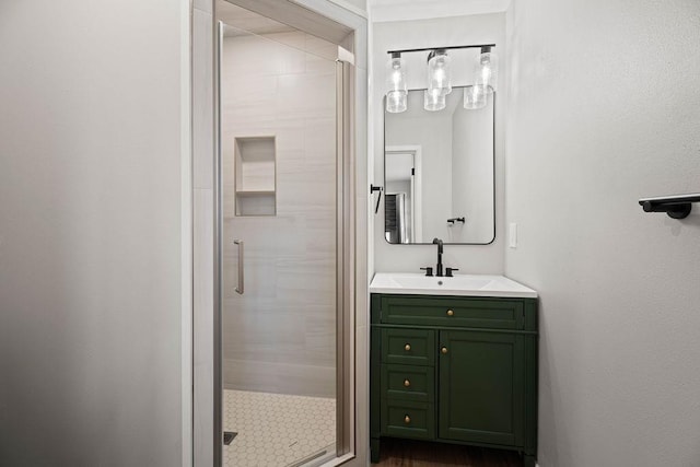 bathroom featuring a shower with door and vanity