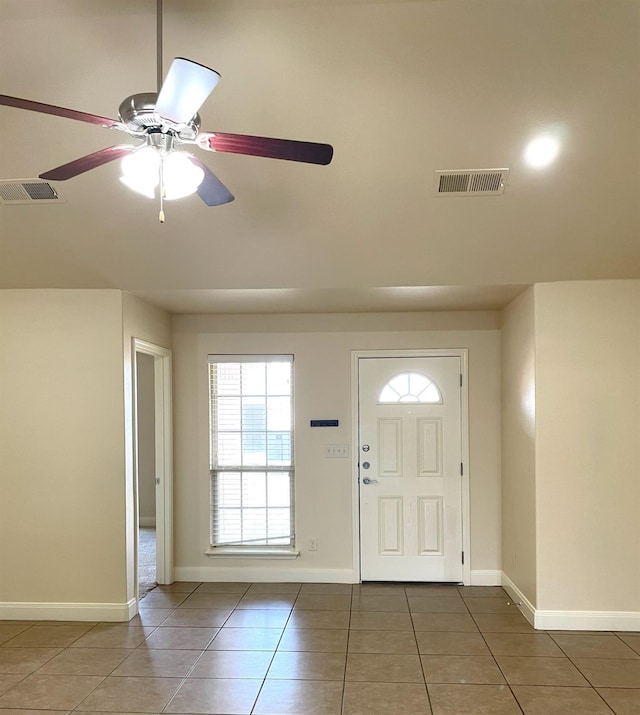 foyer entrance featuring ceiling fan, dark tile patterned flooring, visible vents, and baseboards