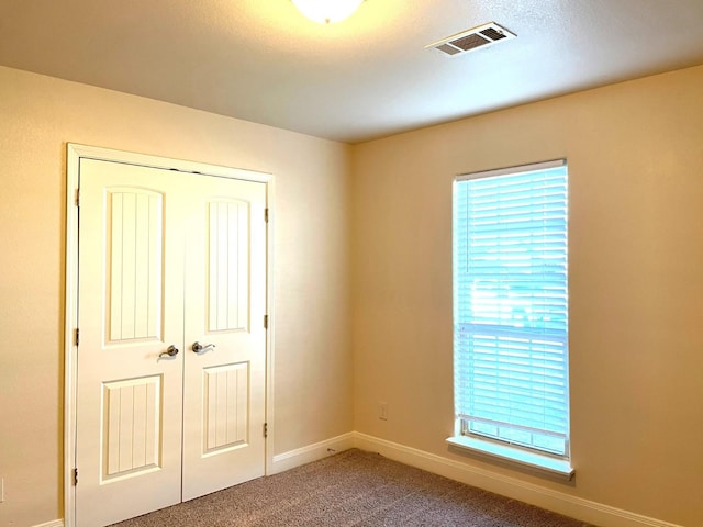 unfurnished bedroom with carpet floors and a closet