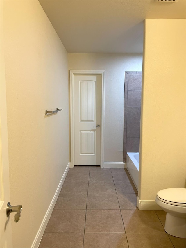 bathroom with tile patterned flooring, toilet, baseboards, walk in shower, and a bathtub