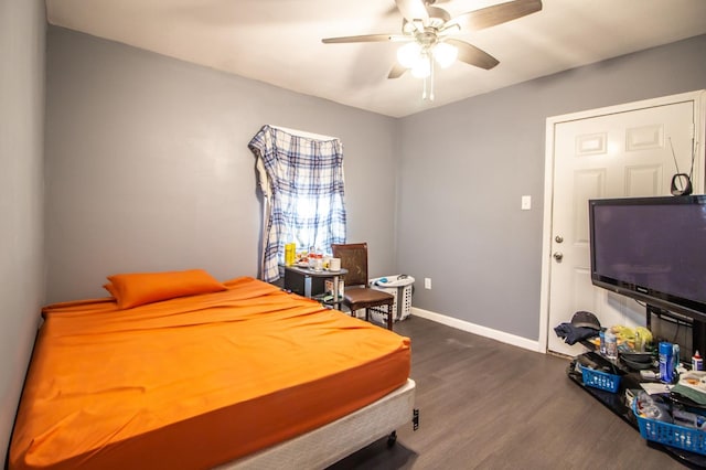 bedroom with dark hardwood / wood-style flooring and ceiling fan