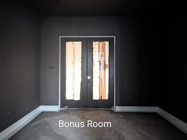 unfurnished room featuring french doors