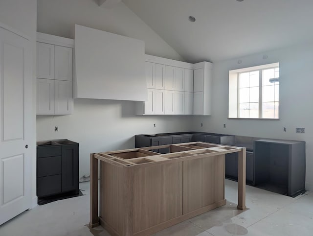 kitchen featuring white cabinetry and vaulted ceiling