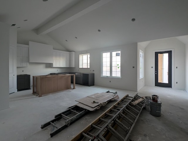 kitchen featuring beamed ceiling, high vaulted ceiling, a kitchen island, and white cabinets